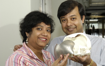 Engineers holding a skull with artificial implant